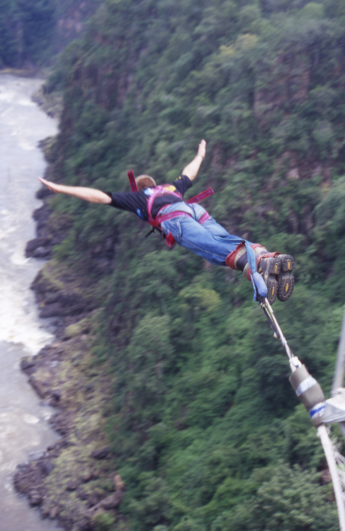 "A man bungee jumps off Victoria Falls Bridge, which spans the Zambezi River."